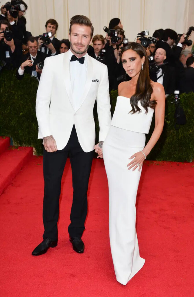Victoria, con il marito David, indossa un abito bianco senza spalline al Met Gala del 2014