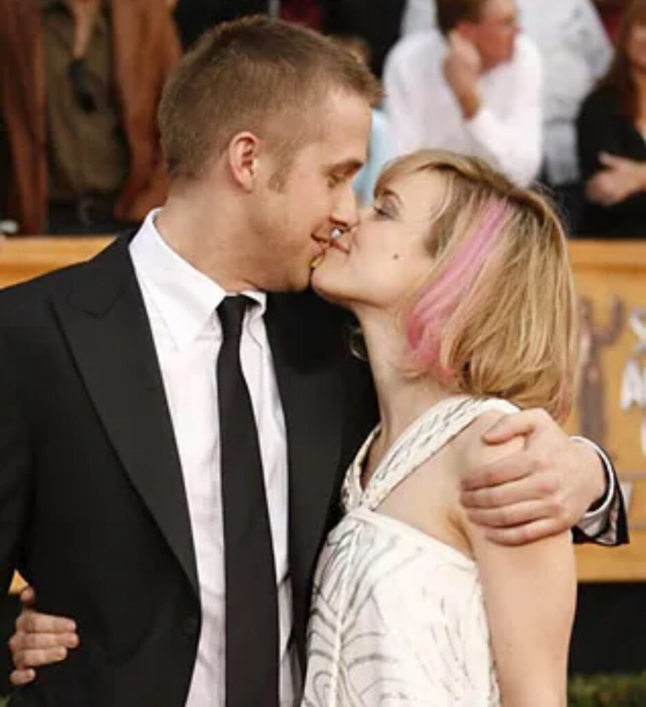 Rachel Mc Adams con un ciuffo di capelli rosa e Ryan Gosling si danno un bacio sul red carpet