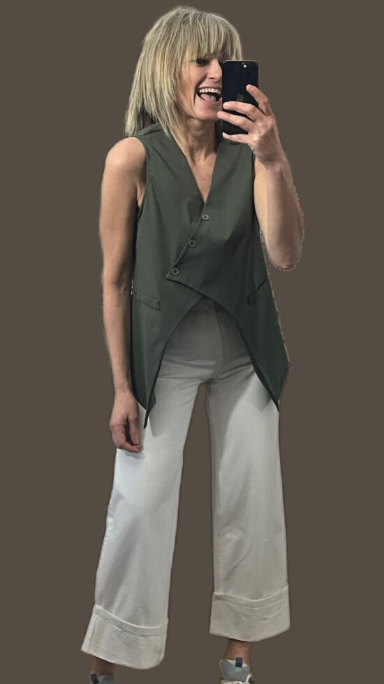 gilet smanicato con taglio asimettrico verde militare abbinato al pantalone bianco