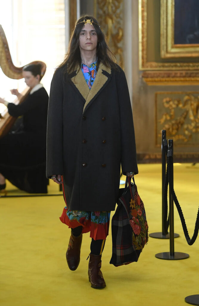 Lucio Corsi con cappotto e vestito floreale alla sfilata Cruise di Gucci