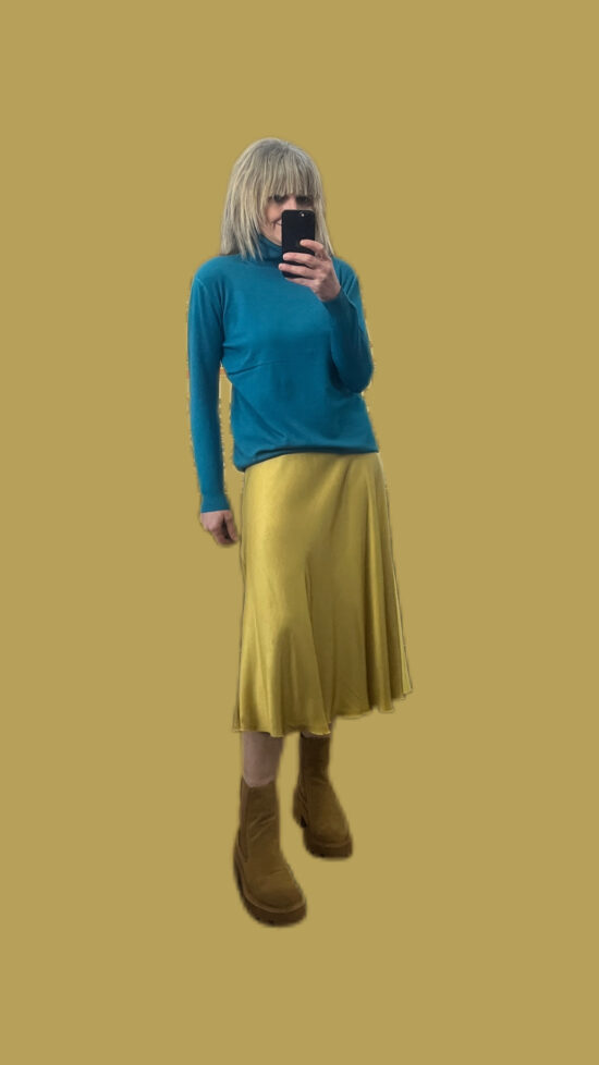 maglia lupetto a collo alto abbinato a gonna giallo oro
