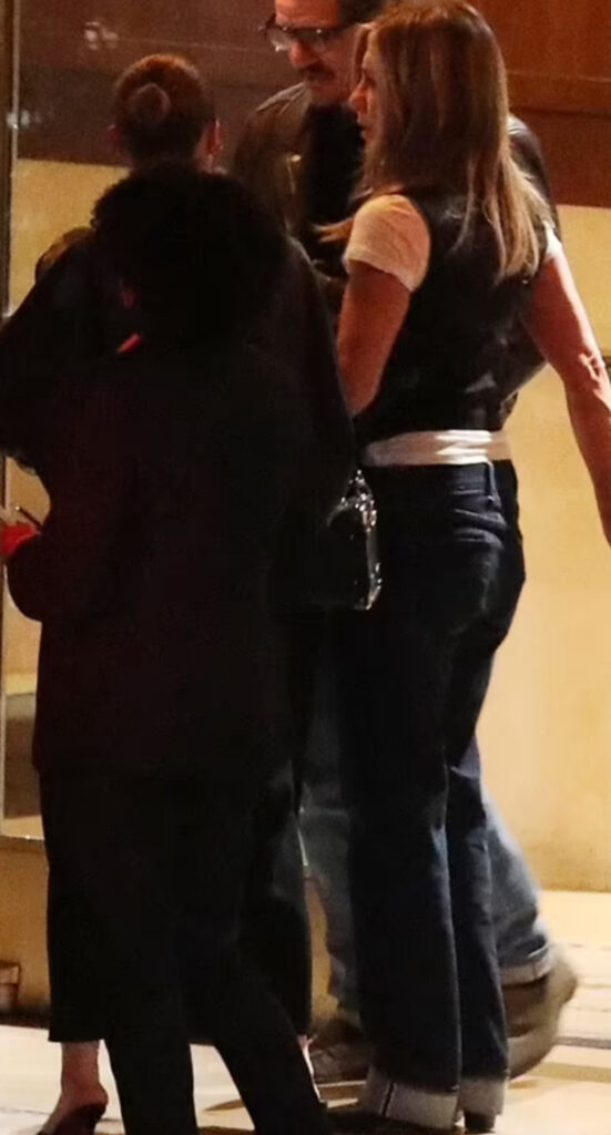 Jennifer Aniston con t shirt bianca e gilet nero all'uscita del ristorante con Pedro Pascal e un'amica